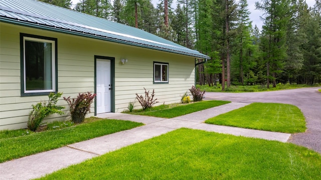13033 Trinkus Ln, Bigfork, MT 59911 - doorway to property with metal roof and a lawn
