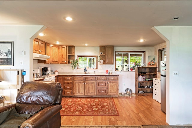 874 Coal Pit Rd, Corvallis, MT 59828 - kitchen featuring open shelves, under cabinet range hood, white gas stove, open floor plan, and light wood-style floors