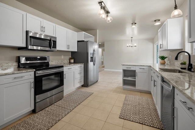 28 Bethany St, Columbia Falls, MT 59912 - kitchen featuring appliances with stainless steel finishes, a sink, light tile patterned floors, a chandelier, and hanging light fixtures