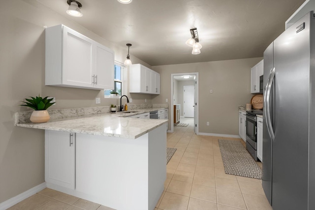 28 Bethany St, Columbia Falls, MT 59912 - kitchen with appliances with stainless steel finishes, a peninsula, a sink, light tile patterned floors, and white cabinets