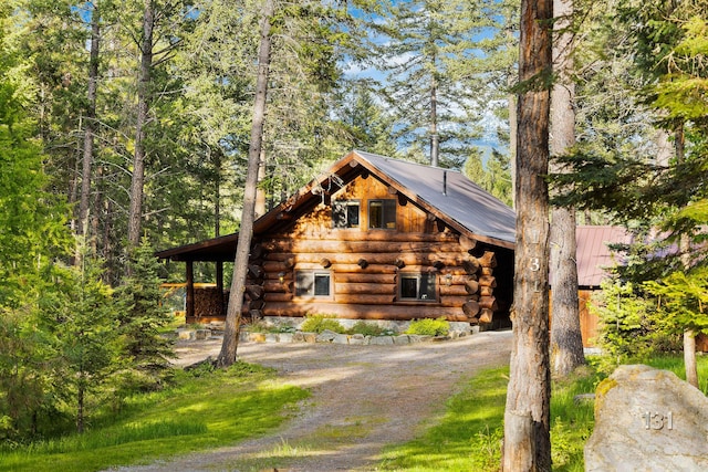 131 Mccaffery Lookout Trl, Bigfork, MT 59911 - log cabin with log exterior, metal roof, and driveway