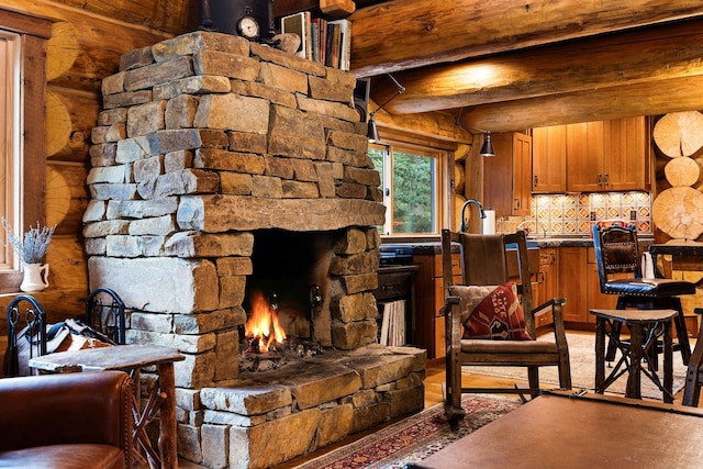 131 Mccaffery Lookout Trl, Bigfork, MT 59911 - living area featuring log walls, beam ceiling, and a stone fireplace