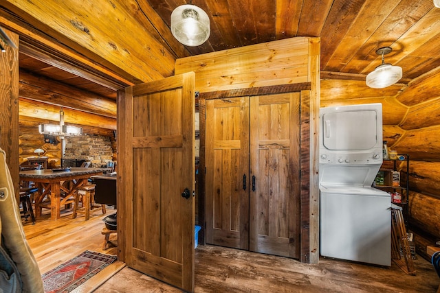 131 Mccaffery Lookout Trl, Bigfork, MT 59911 - laundry room featuring stacked washing machine and dryer, wood ceiling, log walls, and wood finished floors