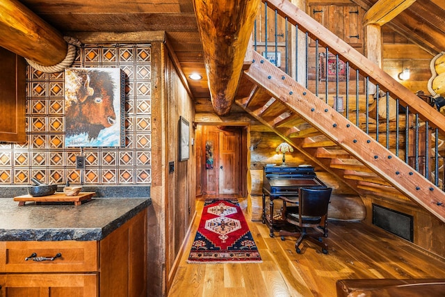 131 Mccaffery Lookout Trl, Bigfork, MT 59911 - staircase with wood ceiling with exposed beams, hardwood / wood-style floors, and wooden walls
