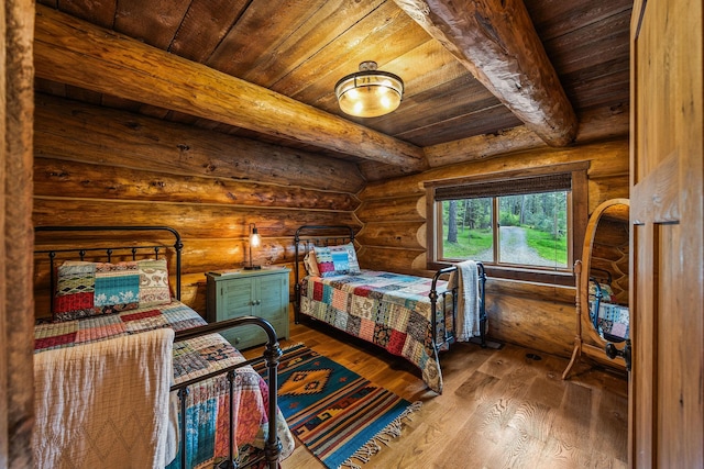 131 Mccaffery Lookout Trl, Bigfork, MT 59911 - bedroom with wood ceiling with exposed beams, log walls, and wood finished floors