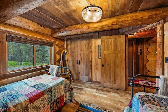 131 Mccaffery Lookout Trl, Bigfork, MT 59911 - bedroom featuring wooden ceiling with exposed beams, hardwood / wood-style flooring, wooden walls, and log walls