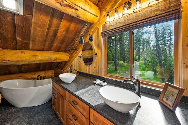 131 Mccaffery Lookout Trl, Bigfork, MT 59911 - full bathroom with a freestanding bath, wood ceiling, double vanity, vaulted ceiling, and wood walls