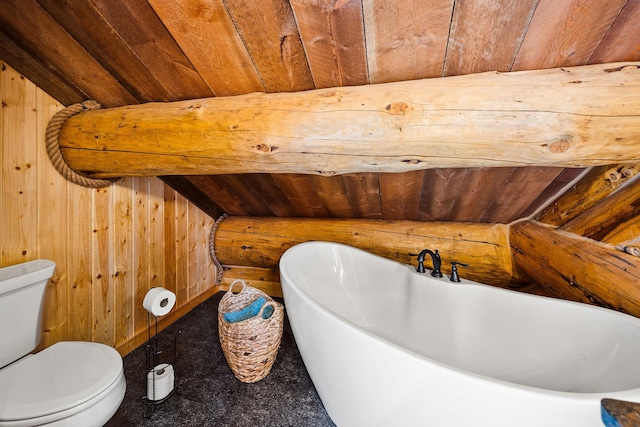 131 Mccaffery Lookout Trl, Bigfork, MT 59911 - bathroom featuring a freestanding tub, wood ceiling, wooden walls, and toilet