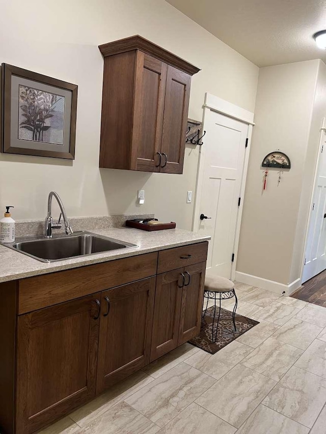 2669 Bunkhouse Pl, Missoula, MT 59808 - kitchen with a sink, dark brown cabinetry, light marble finish floors, and baseboards