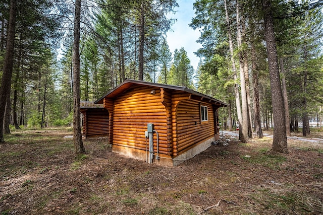 204 Cougar Meadow Dr, Saint Regis, MT 59866 - view of property exterior with log siding, a forest view, and an outbuilding