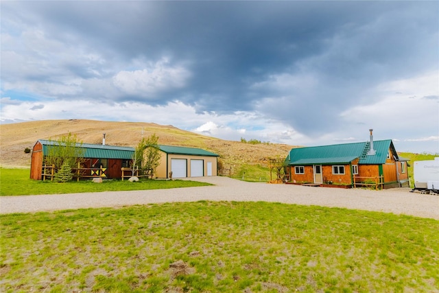 34 Outlaw Trl, Anaconda, MT 59711 - view of grassy yard featuring an outbuilding, a mountain view, and driveway