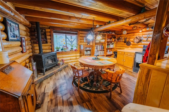 34 Outlaw Trl, Anaconda, MT 59711 - dining space with a wood stove, light wood finished floors, beam ceiling, and log walls