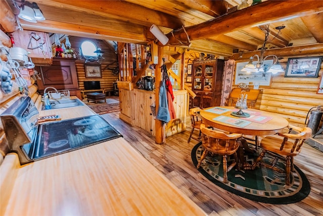 34 Outlaw Trl, Anaconda, MT 59711 - dining space with log walls, hardwood / wood-style floors, a chandelier, and wooden ceiling with exposed beams