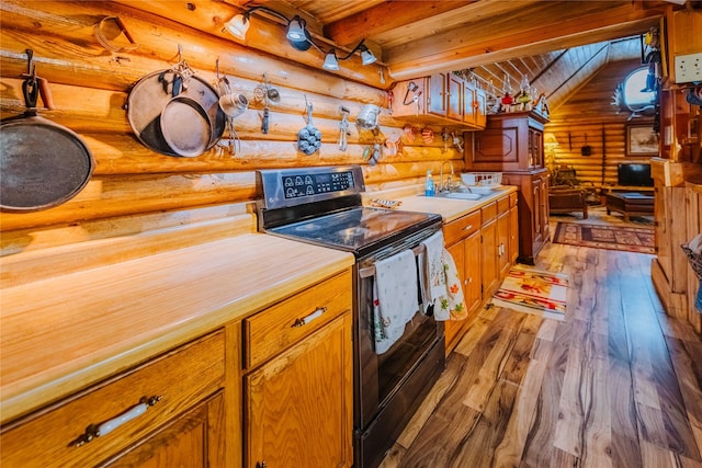 34 Outlaw Trl, Anaconda, MT 59711 - kitchen featuring black range with electric stovetop, rustic walls, wood finished floors, wooden ceiling with exposed beams, and light countertops