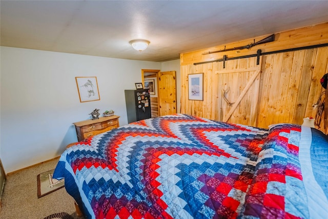 34 Outlaw Trl, Anaconda, MT 59711 - carpeted bedroom featuring wood walls, a barn door, and baseboards