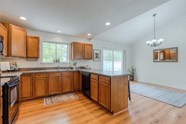 115 River Glen Ct, Kalispell, MT 59901 - kitchen with black appliances, vaulted ceiling, a peninsula, plenty of natural light, and brown cabinetry