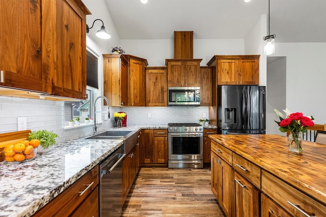 11515 Ninebark Way, Missoula, MT 59802 - kitchen with appliances with stainless steel finishes, a sink, light stone countertops, wood finished floors, and brown cabinetry