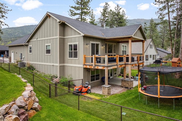11515 Ninebark Way, Missoula, MT 59802 - rear view of house with a trampoline, board and batten siding, central AC unit, a shingled roof, and a patio