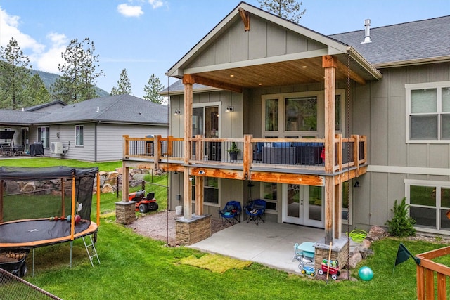 11515 Ninebark Way, Missoula, MT 59802 - back of property with a trampoline, a patio, a yard, french doors, and board and batten siding