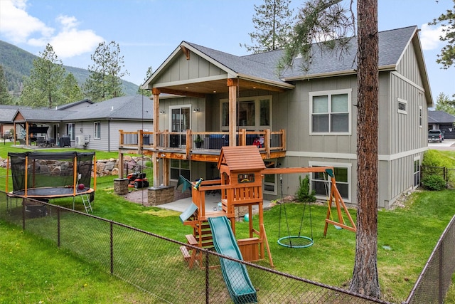 11515 Ninebark Way, Missoula, MT 59802 - back of property featuring a trampoline, roof with shingles, a playground, board and batten siding, and a deck with mountain view