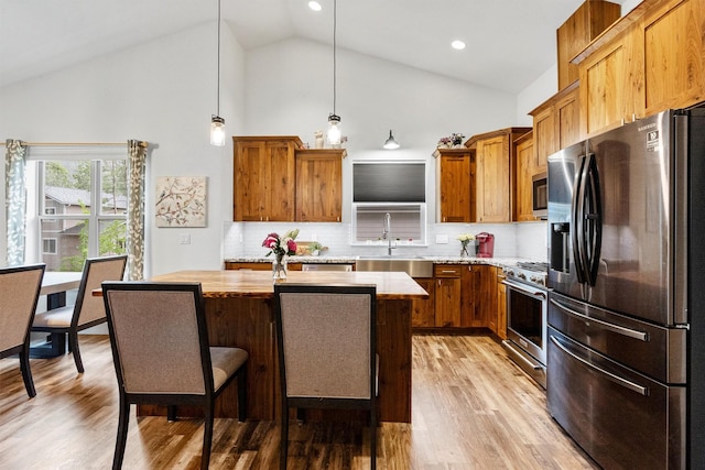 11515 Ninebark Way, Missoula, MT 59802 - kitchen featuring appliances with stainless steel finishes, a sink, a center island, high vaulted ceiling, and pendant lighting