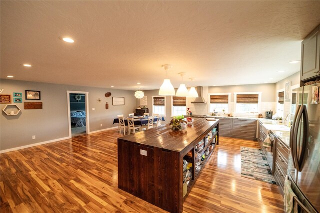 1610 Maple Dr, Fort Benton, MT 59442 - kitchen with freestanding refrigerator, butcher block counters, light wood-type flooring, recessed lighting, and wall chimney exhaust hood