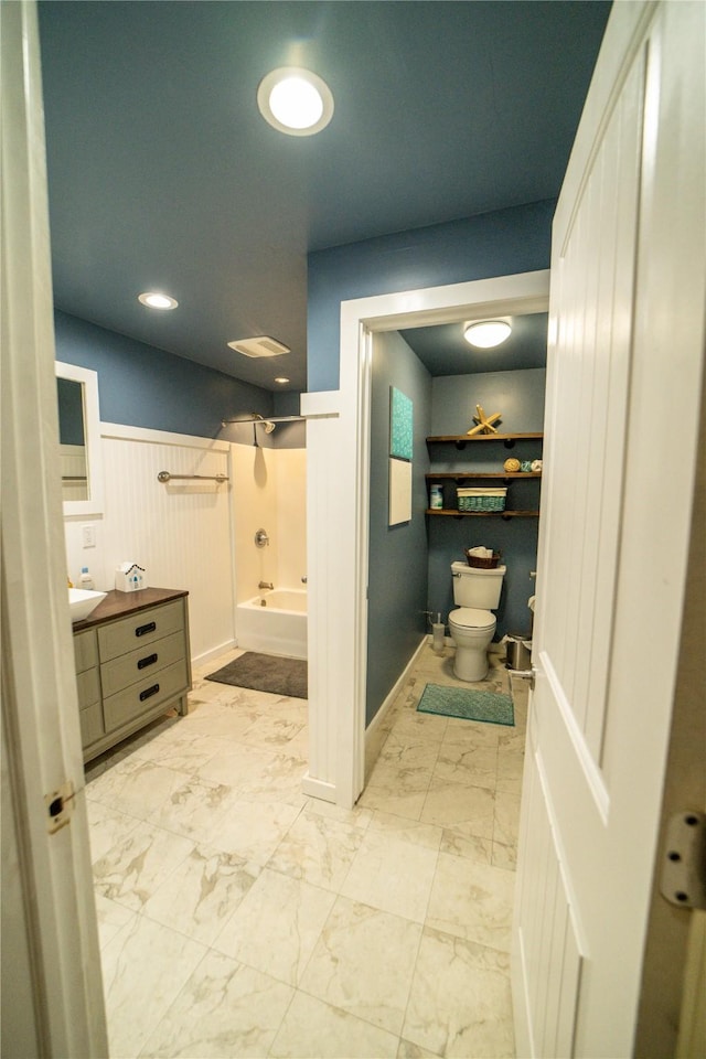 1610 Maple Dr, Fort Benton, MT 59442 - bathroom with toilet, marble finish flooring, vanity, shower / bathtub combination, and a wainscoted wall