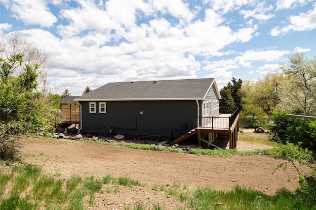 1610 Maple Dr, Fort Benton, MT 59442 - back of property with stairway, a deck, and roof with shingles