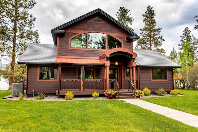 46274 Meadowlark Ln, Big Arm, MT 59910 - rustic home featuring cooling unit, a front lawn, covered porch, a standing seam roof, and metal roof