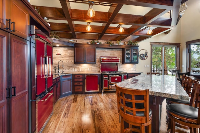 46274 Meadowlark Ln, Big Arm, MT 59910 - kitchen with light wood-style floors, backsplash, a sink, beam ceiling, and light stone countertops