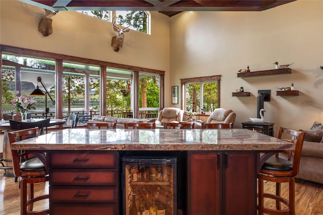 46274 Meadowlark Ln, Big Arm, MT 59910 - bar area with beverage cooler, a wood stove, and light wood-type flooring