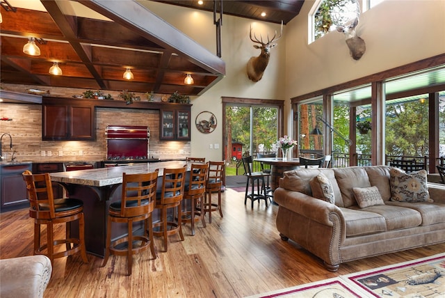 46274 Meadowlark Ln, Big Arm, MT 59910 - bar featuring wooden ceiling with exposed beams, plenty of natural light, light wood-type flooring, decorative backsplash, and coffered ceiling