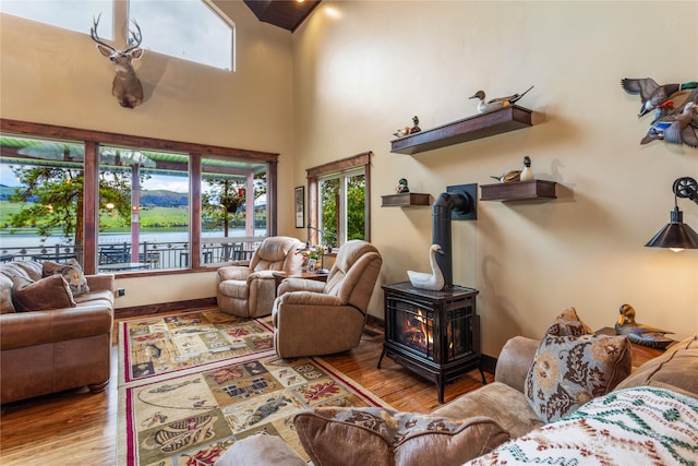 46274 Meadowlark Ln, Big Arm, MT 59910 - living area with a wood stove, healthy amount of natural light, wood finished floors, and a towering ceiling