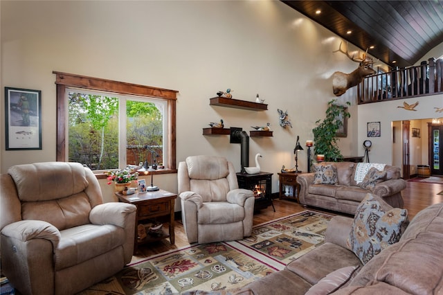 46274 Meadowlark Ln, Big Arm, MT 59910 - living room featuring high vaulted ceiling, wood finished floors, and a wood stove