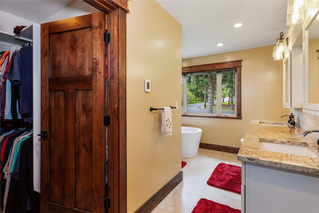 46274 Meadowlark Ln, Big Arm, MT 59910 - full bath with double vanity, a freestanding tub, baseboards, recessed lighting, and a walk in closet