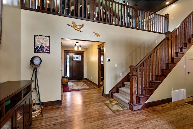 46274 Meadowlark Ln, Big Arm, MT 59910 - foyer with wood finished floors, baseboards, a towering ceiling, and stairs