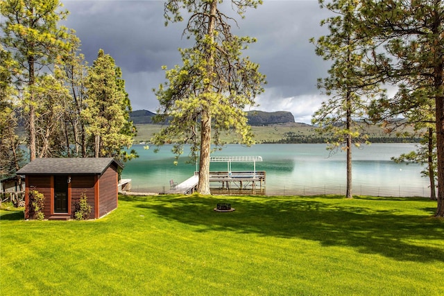 46274 Meadowlark Ln, Big Arm, MT 59910 - view of green lawn featuring a water view, boat lift, a dock, and an outbuilding