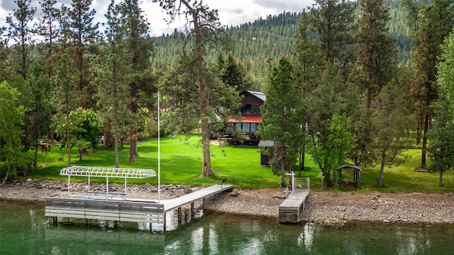 46274 Meadowlark Ln, Big Arm, MT 59910 - dock area featuring a lawn, a water view, and a wooded view