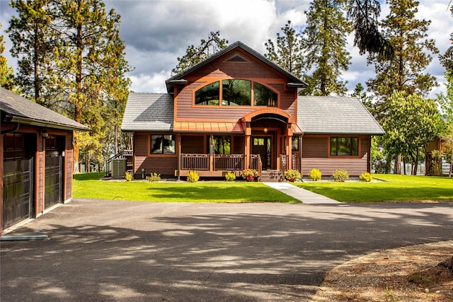 46274 Meadowlark Ln, Big Arm, MT 59910 - rustic home featuring covered porch, a garage, a front lawn, a standing seam roof, and metal roof