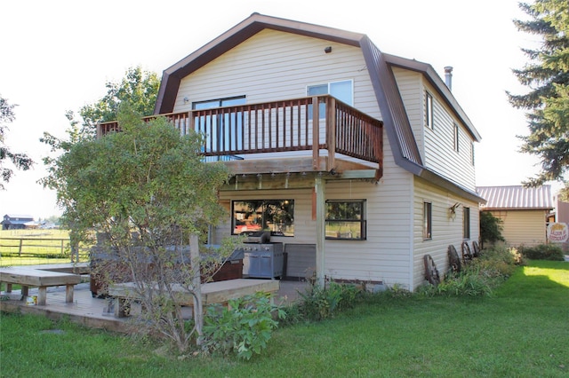 34575 Gunlock Rd, Charlo, MT 59824 - rear view of house with a gambrel roof, a yard, and a wooden deck
