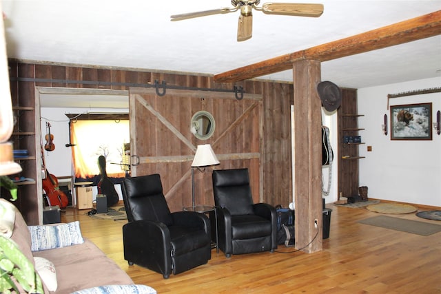 34575 Gunlock Rd, Charlo, MT 59824 - living room with wood walls, wood finished floors, ceiling fan, and beam ceiling