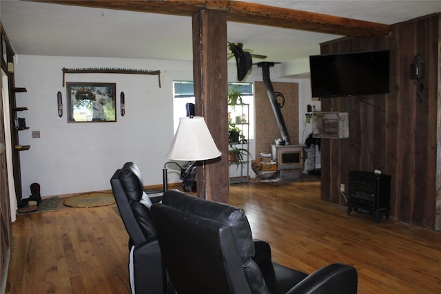 34575 Gunlock Rd, Charlo, MT 59824 - living room featuring a wood stove, wood finished floors, and beamed ceiling