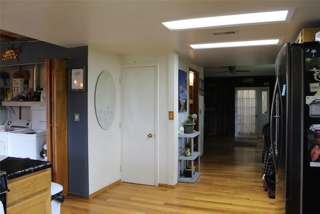 34575 Gunlock Rd, Charlo, MT 59824 - entrance foyer with washing machine and clothes dryer, light wood-style flooring, ceiling fan, and baseboards