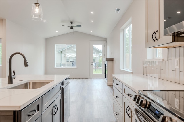 1050 Mill Creek Dr, Bigfork, MT 59911 - kitchen with a sink, appliances with stainless steel finishes, ceiling fan, light stone counters, and light wood-style flooring