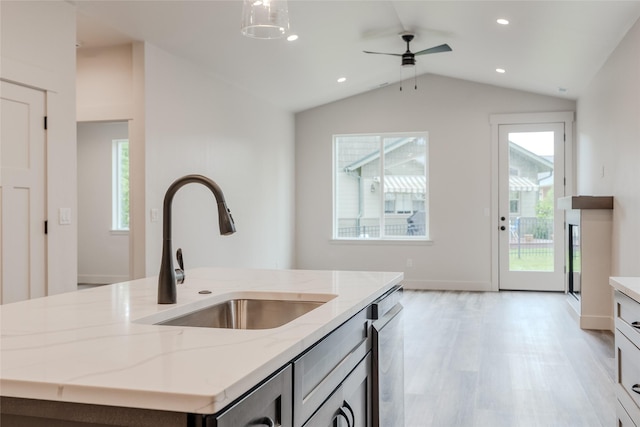 1050 Mill Creek Dr, Bigfork, MT 59911 - kitchen with a sink, light stone countertops, light wood finished floors, lofted ceiling, and a ceiling fan