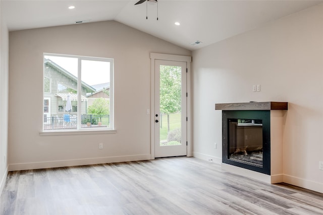 1050 Mill Creek Dr, Bigfork, MT 59911 - unfurnished living room featuring a glass covered fireplace, wood finished floors, ceiling fan, lofted ceiling, and recessed lighting