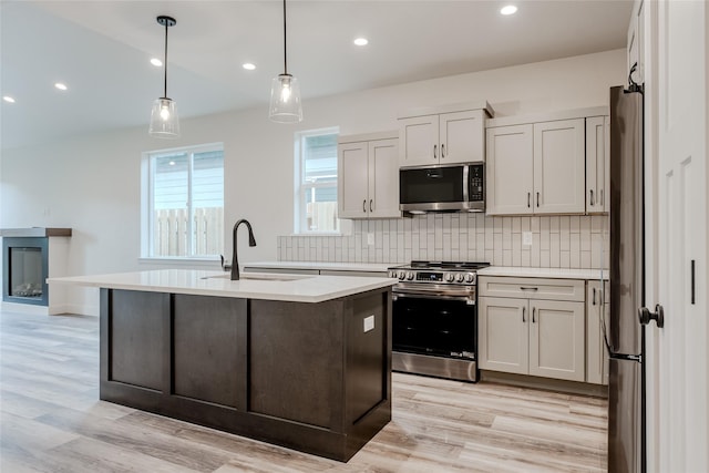 1050 Mill Creek Dr, Bigfork, MT 59911 - kitchen featuring stainless steel appliances, light countertops, a sink, backsplash, and recessed lighting