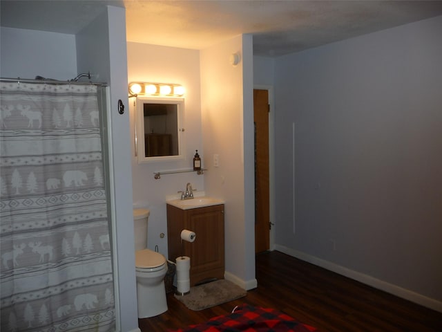 3115 8th Ave N, Great Falls, MT 59401 - bathroom with wood finished floors, vanity, toilet, baseboards, and a shower with shower curtain