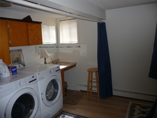 3115 8th Ave N, Great Falls, MT 59401 - washroom with baseboard heating, a baseboard heating unit, wood finished floors, and washer and dryer