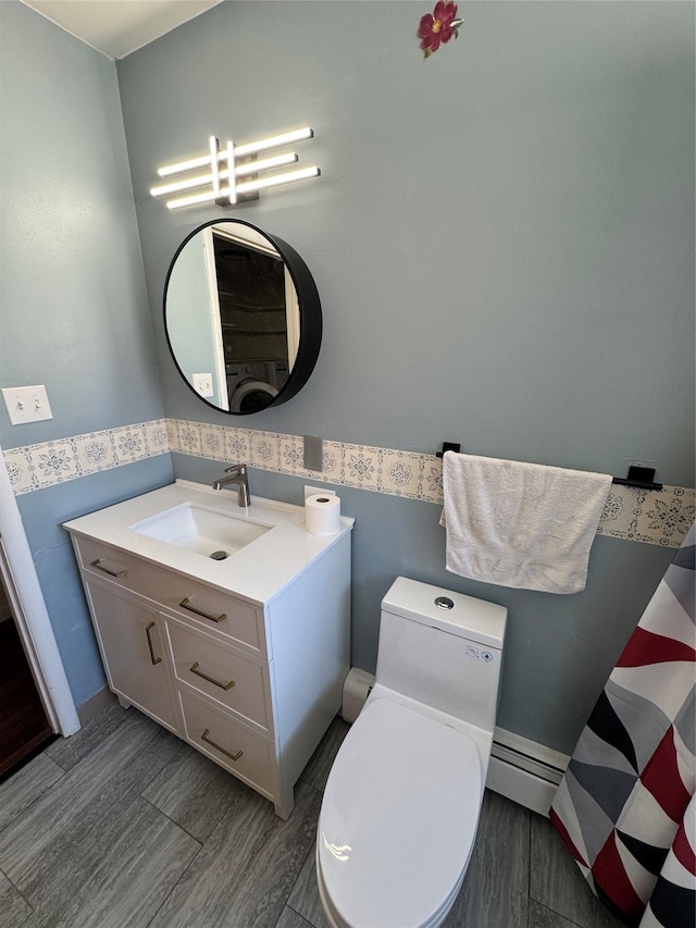 3115 8th Ave N, Great Falls, MT 59401 - bathroom featuring a baseboard heating unit, vanity, wood finished floors, wainscoting, and wallpapered walls